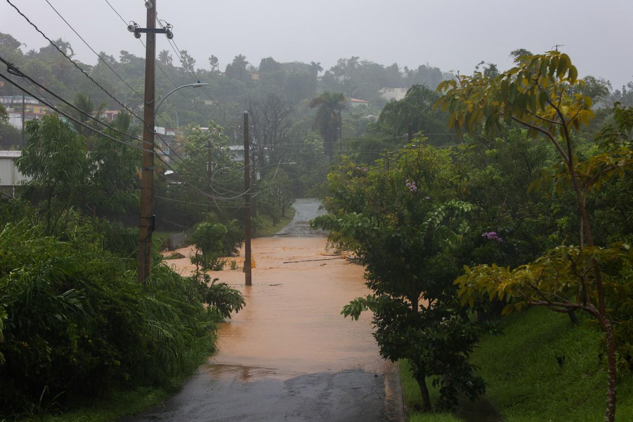 A road is flooded by the rains of Hurricane Fiona in Cayey, Puerto Rico, Sunday, Sept. 18, 2022.