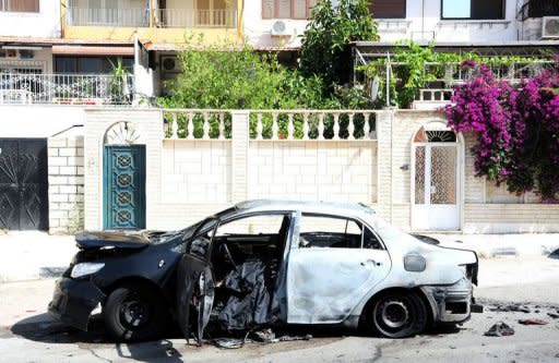 A Syrian Arab News Agency photo from on June 11, 2012 shows a burnt car the government says was blown up by an armed group in the neighbourhood of Barza in Damascus. More than 14,100 people have been killed since an anti-regime revolt broke out in March last year, including 9,862 civilians, 3,470 soldiers and 783 army defectors, according to the watchdog