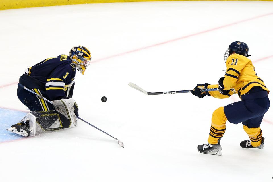 Quinnipiac forward Collin Graf (11) shoots the puck on Michigan goaltender Erik Portillo (1) during the second period in the semifinals of the 2023 Frozen Four at Amalie Arena in Tampa, Florida, on Thursday, April 6, 2023.