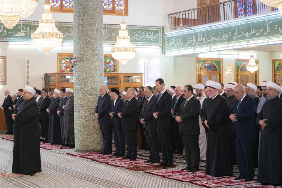 In this photo released by the Syrian official news agency SANA, Syrian President Bashar Assad, fifth right, prays on the first day of Eid al-Fitr, that marks the end of the Muslim holy month of Ramadan at the Hafez Assad masque in Damascus, Syria, Friday, April 21, 2023. (AP Photo)