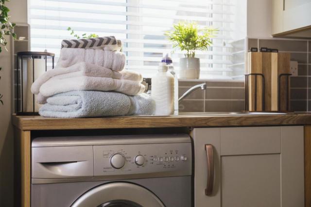 Woman Loading Washing Machine In Kitchen High-Res Stock Photo - Getty Images