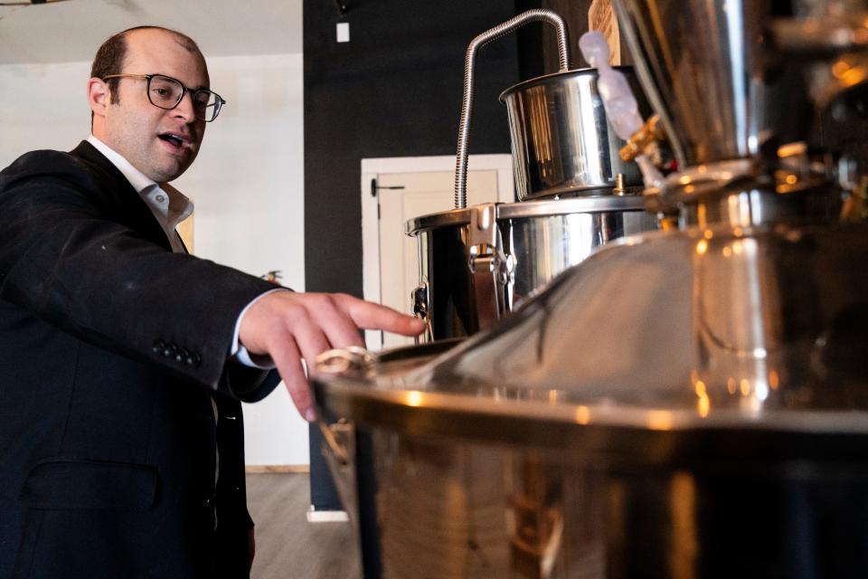 Mar 21, 2024; Passaic, N.J., United States; Rabbi Binyomin Terebelo, a master distiller and owner of ExquisiteSip Distillery, points to a distiller on Thursday afternoon.