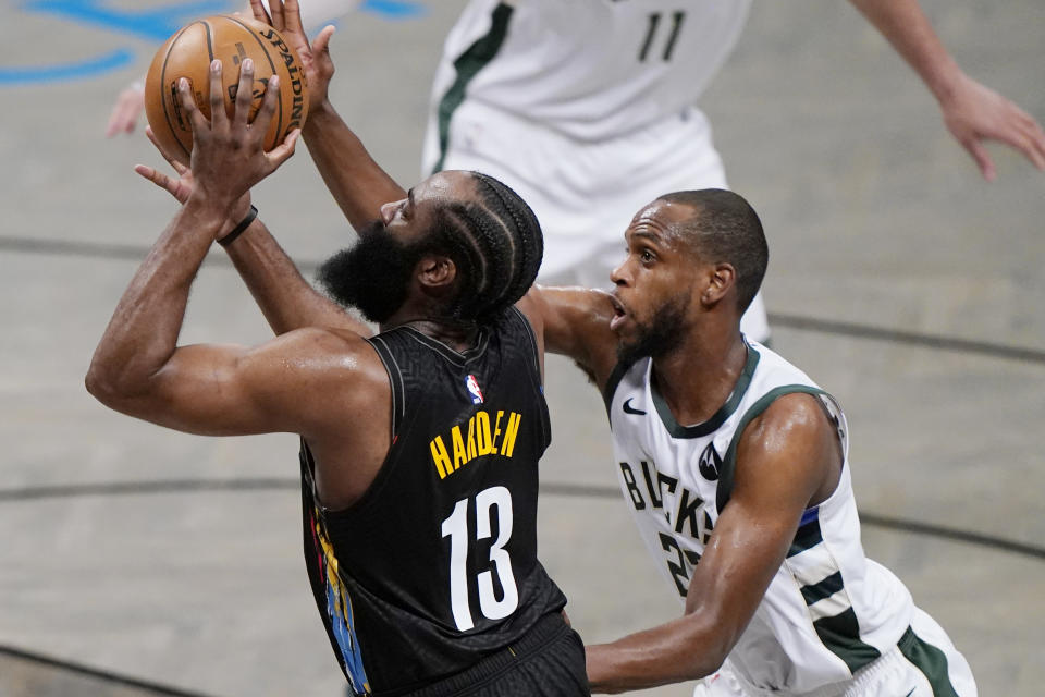 Milwaukee Bucks forward Khris Middleton (22) defends against Brooklyn Nets guard James Harden (13) during the second half of Game 5 of a second-round NBA basketball playoff series Tuesday, June 15, 2021, in New York. (AP Photo/Kathy Willens)
