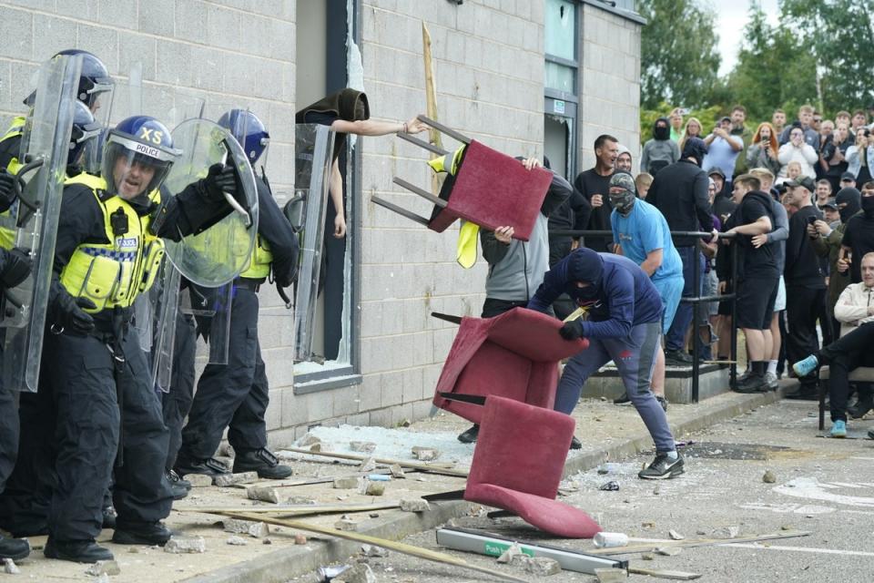 A chair is thrown at police officers in front of the hotel (PA Wire)