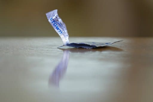 An empty condom package rests on a table during the shooting of a porn scene for the adult film production company Vivid, in 2004, on the set in Canoga Park, California. US porn film producers vowed to go to court to challenge a decision by Los Angeles County voters requiring actors in adult movies to wear condoms while performing on set