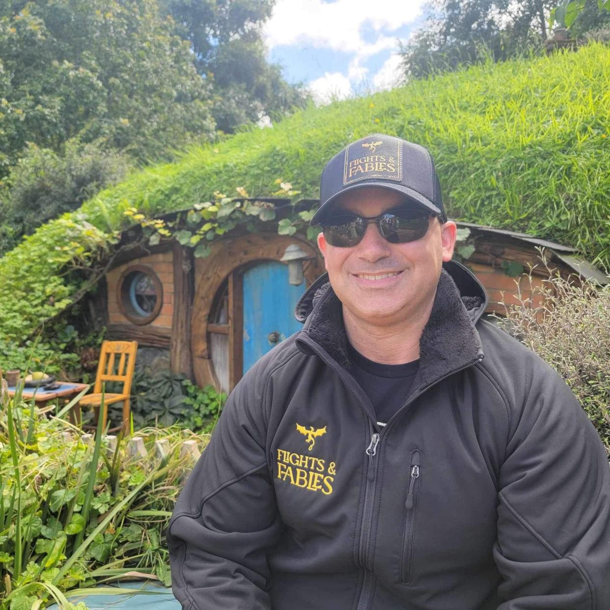 Rocky Dimico, owner of Fayetteville-based fantasy-travel agency, at the Hobbiton Movie Set in New Zealand, the village from the Lord of the Rings and the Hobbit movies. Dimico curates travel itineraries for fantasy enthusiasts with his travel agency.