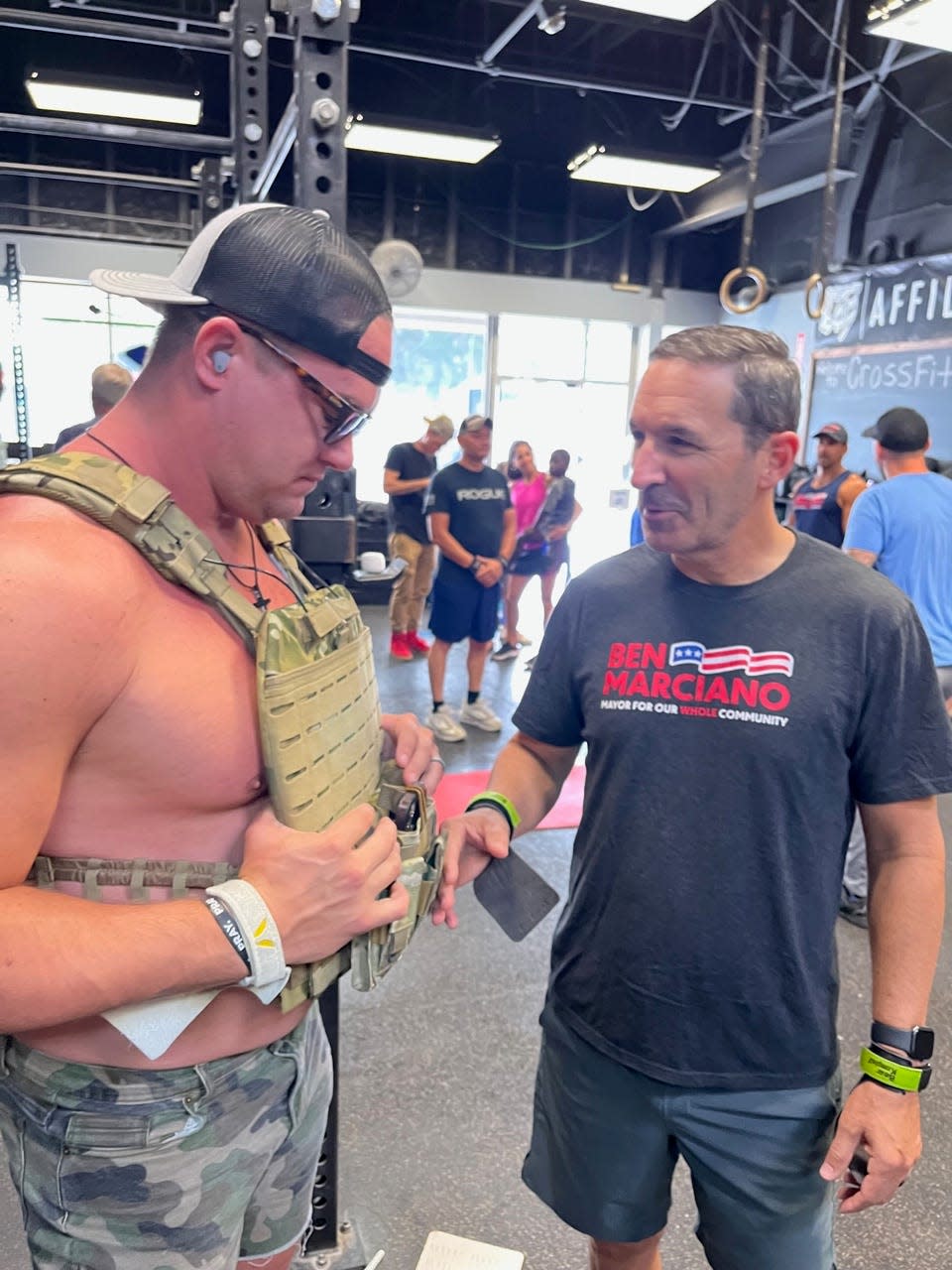 Beau Broker, left, wearing a weighted vest to replicate gear worn by troops, speaks with Ken Ausley at Zone Heath & Fitness in Ocala as both men prepare to do the Murph workout set on Memorial Day, May 29, 2023.