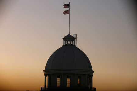 FILE PHOTO: The U.S. Flag and Alabama State Flag fly over the Alabama Governor's Mansion as the state Senate votes on the strictest anti-abortion bill in the United States at the Alabama Legislature in Montgomery, Alabama, U.S. May 14, 2019. REUTERS/Chris Aluka Berry