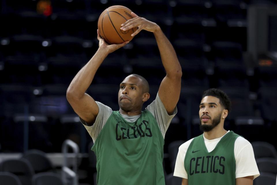 Boston Celtics' Al Horford shoots as Jayson Tatum watches during practice.