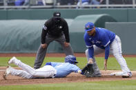 Kansas City Royals Nicky Lopez, left, dives back safely ahead of the tag by Toronto Blue Jays first baseman Rowdy Tellez, right, during the second inning of a baseball game at Kauffman Stadium in Kansas City, Mo., Sunday, April 18, 2021. (AP Photo/Orlin Wagner)
