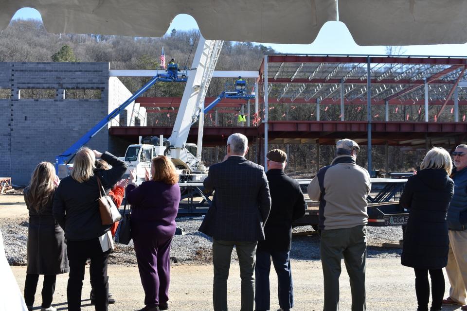 A crowd watches the topping-off ceremony.