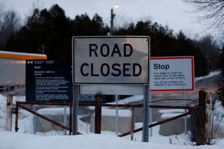 Signs are pictured at the US-Canada border as seen from Roxham Road in Champlain, New York, U.S., February 14, 2018. Picture taken February 14, 2018. REUTERS/Chris Wattie