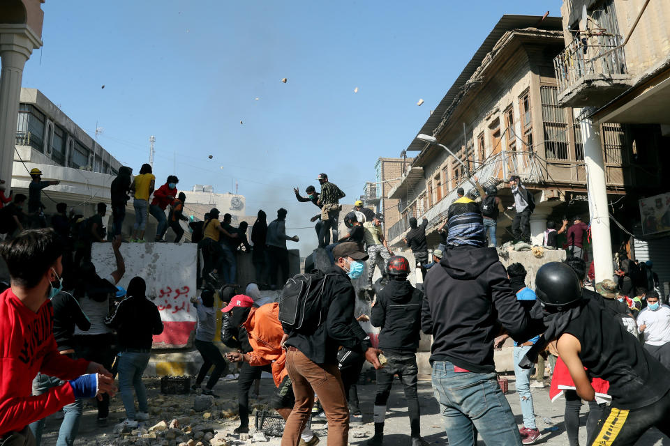 Anti-government protesters gather while security forces block al-Rashid Street during clashes in Baghdad, Iraq, Friday, Nov. 22, 2019. Iraq's massive anti-government protest movement erupted Oct. 1 and quickly escalated into calls to sweep aside Iraq's sectarian system. Protesters occupy several Baghdad squares and parts of three bridges in a standoff with security forces. (AP Photo/Hadi Mizban)