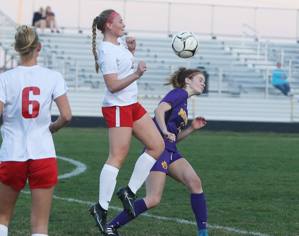 Nevada's Aubrey Thompson (13) and North Polk's Kaylee Koudelka (19) attempt to head the ball during the first half of the 1A No. 4 Cubs' 1-0 victory over the 2A No. 3 Comets at Cubs Stadium Thursday, April 13, 2023, in Nevada, Iowa.