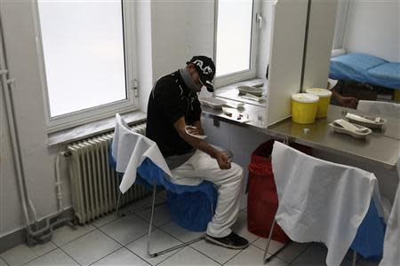 A drug user prepares himself for an injection with a narcotic drug inside a supervised injection room in Athens November 25, 2013. REUTERS/Yorgos Karahalis