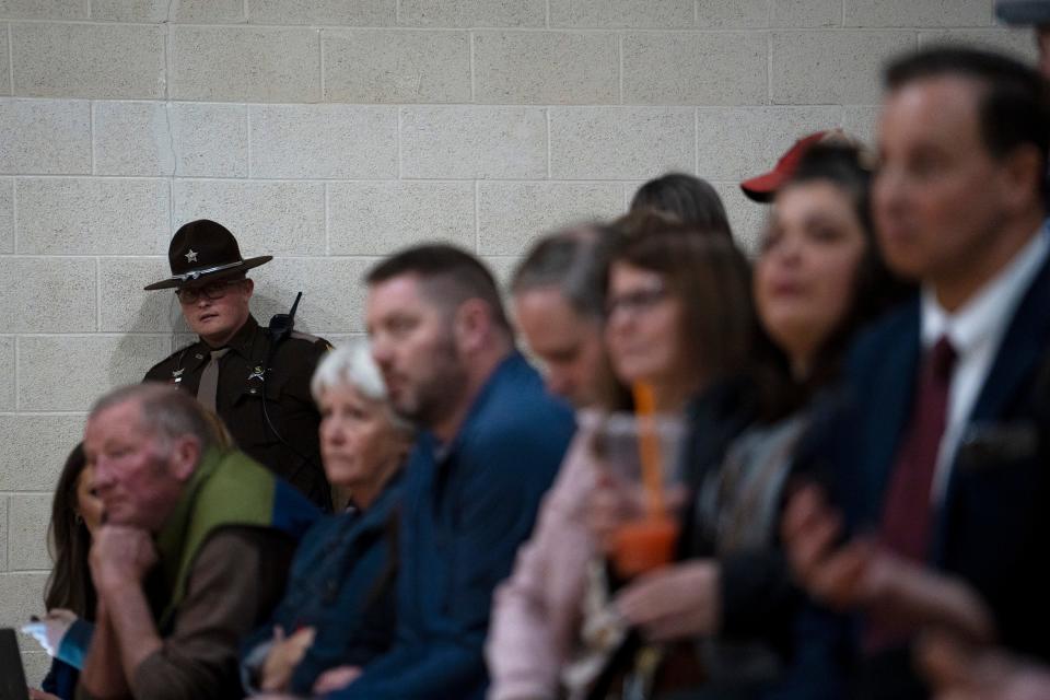 A law enforcement officer watches the crowd as community members ask questions Wednesday, March 1, 2023, during a public meeting held by Heritage Environmental Services at the Russellville Community Center in Russellville, Ind. The landfill operated by Heritage Environmental Services has already taken in three truckloads of contaminated soil from the train derailment in East Palestine, Ohio and expects more in the coming days which has Roachdale and Russellville community members concerned.