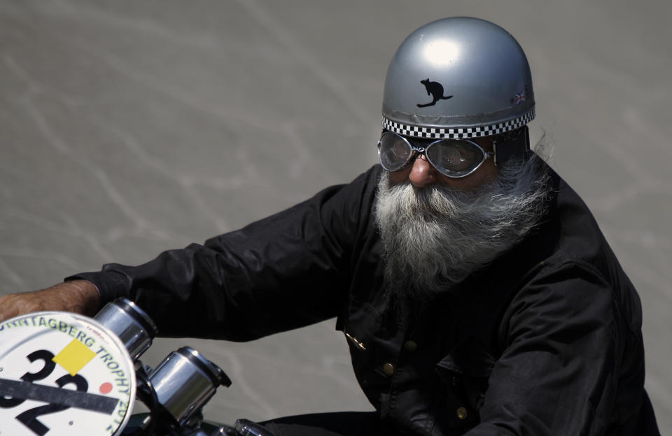 An elderly man leads his motobike on an oval track of a velodrome during an old timer car and motorcycle show in Budapest on May 1, 2012. The event brought life again into the 412 meter long Millennial Velodrome of Budapest, which was built in 1896 and is one of the oldest arenas for track cycling in Europe.  AFP PHOTO / PETER KOHALMIPETER KOHALMI/AFP/GettyImages