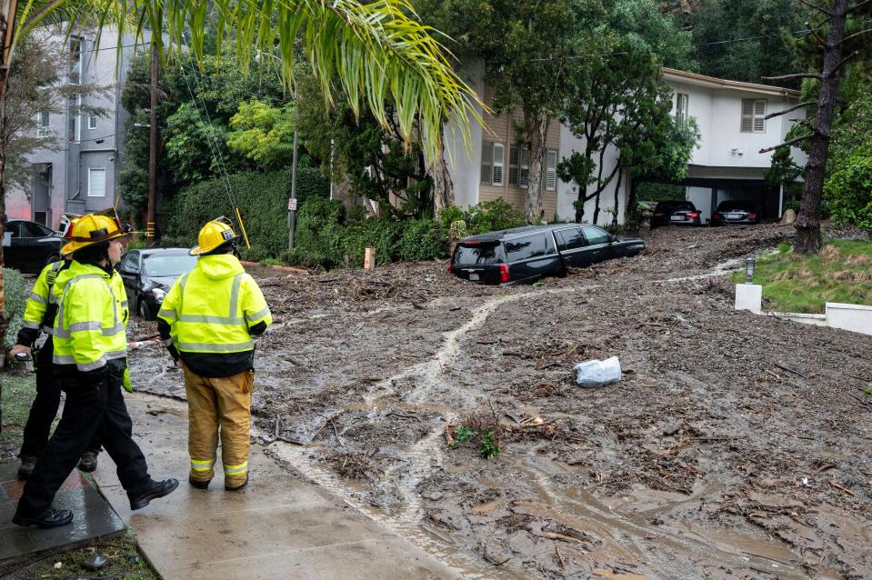 Firefighters look over damage from a large mudslide which occurred at the intersection of Beverly Drive and Beverly Place in the Beverly Crest area of Los Angeles on February 5 (© Los Angeles Daily News/SCNG)