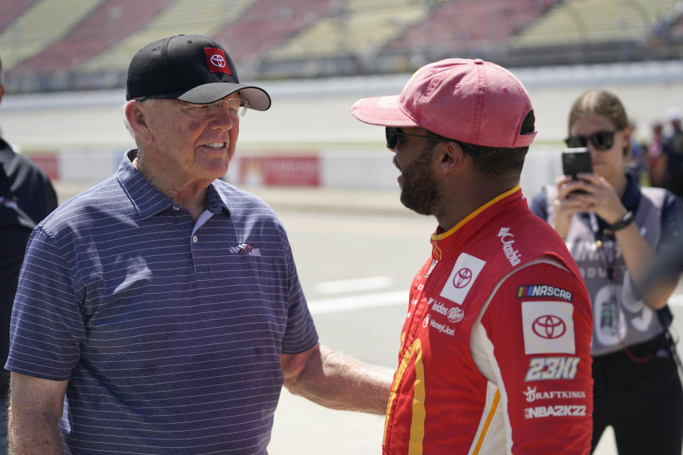 Joe Gibbs, left, congratulates Bubba Wallace, after winning the pole position, during NASCAR Cup Series auto race qualifying at the Michigan International Speedway in Brooklyn, Mich., Saturday, Aug. 6, 2022. (AP Photo/Paul Sancya)