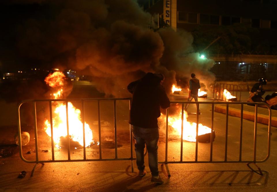 A Sunni protester blocks a major roadway between Beirut and the capital's southern suburbs, a Hezbollah stronghold, in a show of support for residents of the Sunni town of Arsal, in Beirut, Lebanon, Tuesday March 18, 2014. Gunmen from Lebanon's militant Hezbollah group and local Shiite Muslim residents tightened their blockade of the Sunni town of Arsal near the Syrian border Tuesday, sparking concerns that thousands of Syrian refugees stranded in the area could be cut off from humanitarian aid. (AP Photo/Hussein Malla)