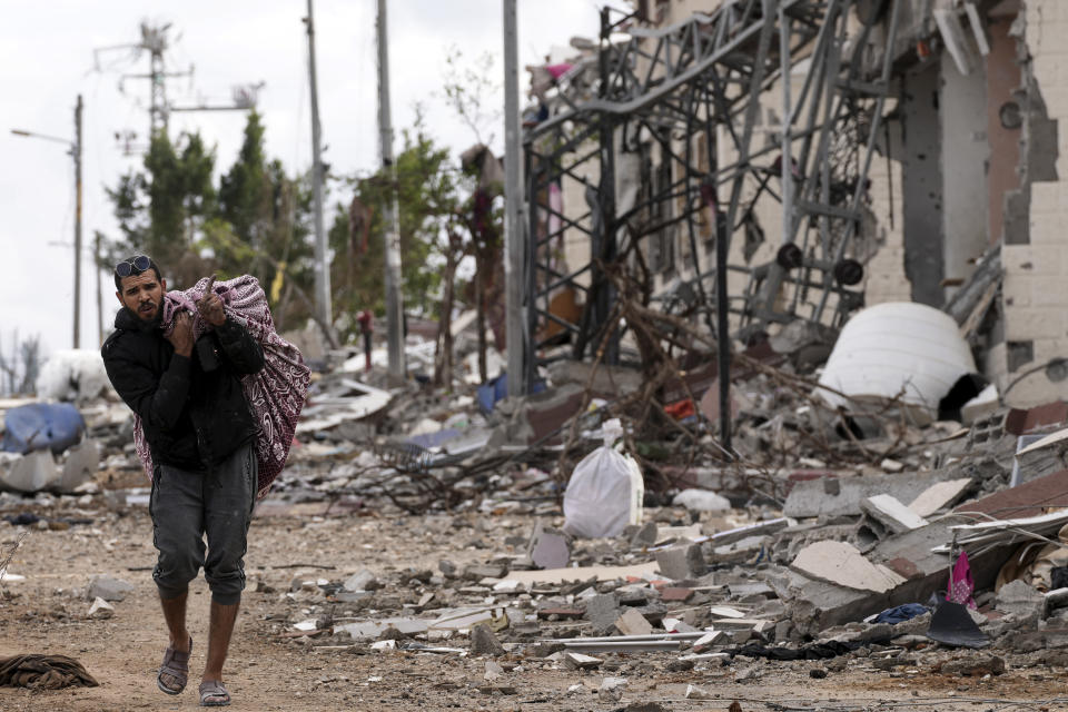 A Palestinian man collects his belongings southeast of the Gaza City on Tuesday, Nov. 28, 2023. on the fifth day of the temporary ceasefire between Hamas and Israel. (AP Photo/Adel Hana)