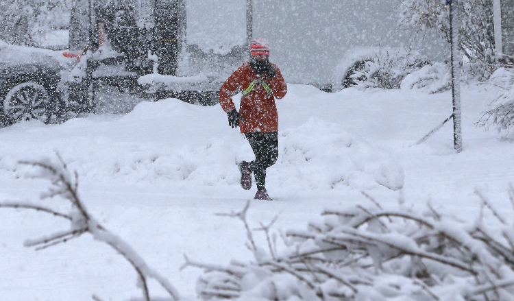 A jogger in the snow Tuesday, March 14, 2023 on Ross Street in South Berwick, Maine.