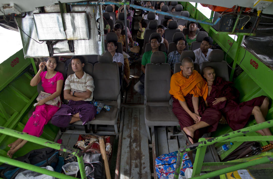 In this Sept. 11, 2013 photo, Buddhist monks and villagers watch television during a ferry boat journey close to Buthidaung in Rakhine state, Myanmar. After closing its doors to the West for half a century, Myanmar has reopened, inviting all to come and discover its treasures, ancient palaces of kings long gone, legends and mysteries told in stone. With ill-equipped roads and railways, there is no better way to explore than by river. Public ferries crisscross through glistening green paddies; old teak fishing boats can be rented by the day. (AP Photo/Gemunu Amarasinghe)