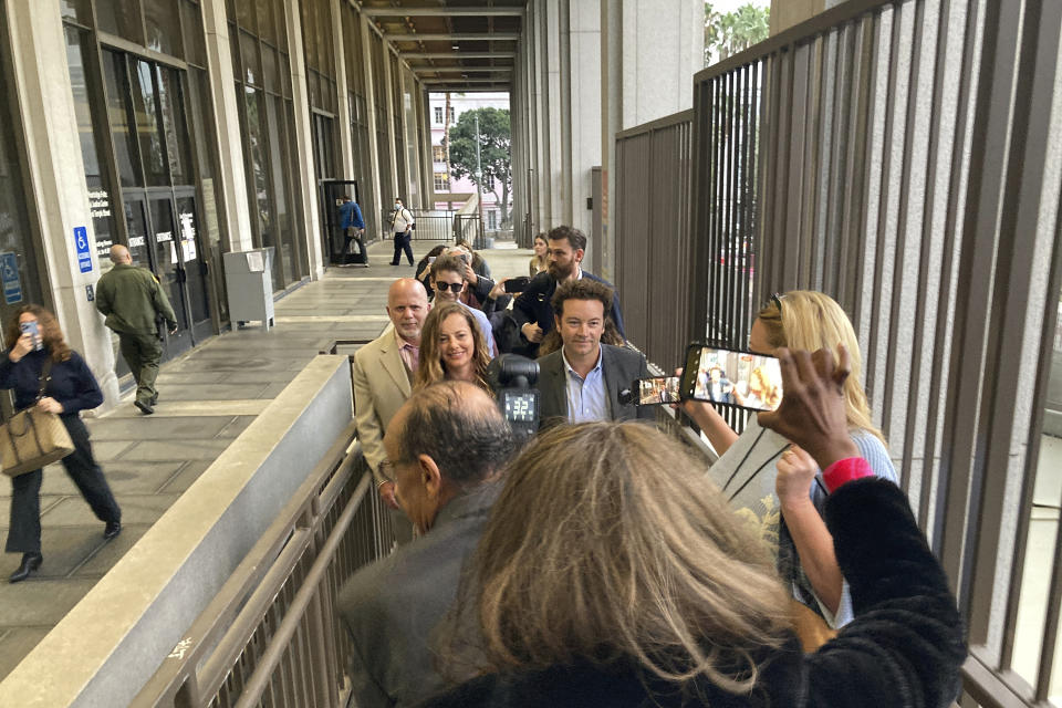 Actor Danny Masterson, middle right, leaves Los Angeles superior Court with his wife Bijou Phillips, middle left, after a judge declared a mistrial in his rape case in Los Angeles on Wednesday, Nov. 30, 2022. Jurors said they were hopelessly deadlocked at the trial of "That '70s Show" actor who was charged with the rape of three women, including a former girlfriend, between 2001 and 2003. (AP Photo/Brian Melley)