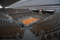 FILE - Rows of empty seats are seen at centre court at the Roland Garros stadium in Paris Sunday, Oct. 11, 2020, as Serbia's Novak Djokovic and Spain's Rafael Nadal warm up for the final match of the French Open tennis tournament. All COVID-19 related restrictions have been lifted and crowds are expected to fill the stadium. (AP Photo/Alessandra Tarantino, FILE)