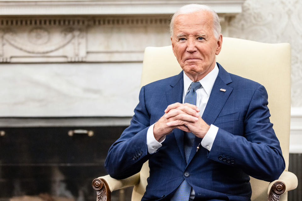 Joe Biden sits and smiles (Samuel Corum / Sipa / Bloomberg via Getty Images)