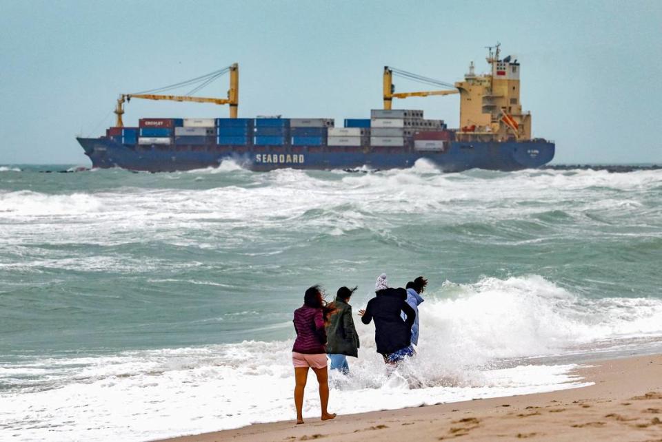 Subha Gaja, Tamil Azh, Vaishu Sank, and Asha Bora, of North Carolina, walk through the waves crashing on the shore as a cargo ship departs the Port of Miami. The friends were vacationing on South Beach in Miami Beach, Florida on Friday, December 15, 2023. 
