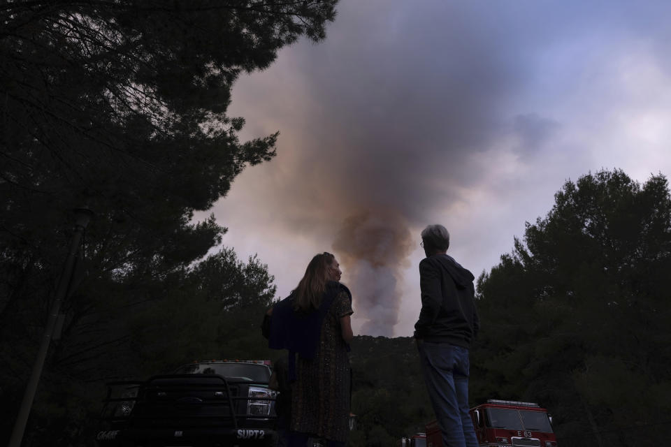 Residents watch a plume of smoke rise from the Palisades Fire in the Pacific Palisades area of Los Angeles, Sunday, May 16, 2021. (AP Photo/Ringo H.W. Chiu)