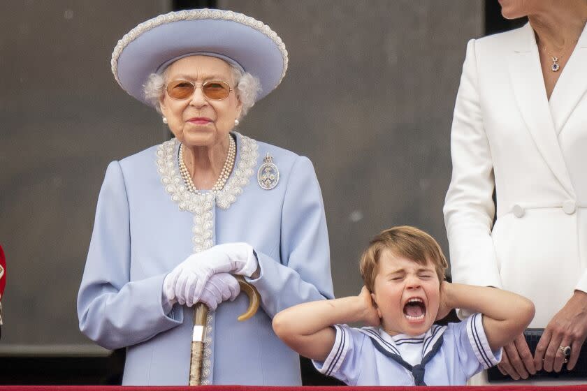 Queen Elizabeth II stands as Prince Louis covers his ears on the balcony of Buckingham Palace after the Trooping the Colour ceremony at Horse Guards Parade, central London, Thursday, June 2, 2022, on the first of four days of celebrations to mark the Platinum Jubilee. The events over a long holiday weekend in the U.K. are meant to celebrate the monarch's 70 years of service. (Aaron Chown/Pool Photo via AP)