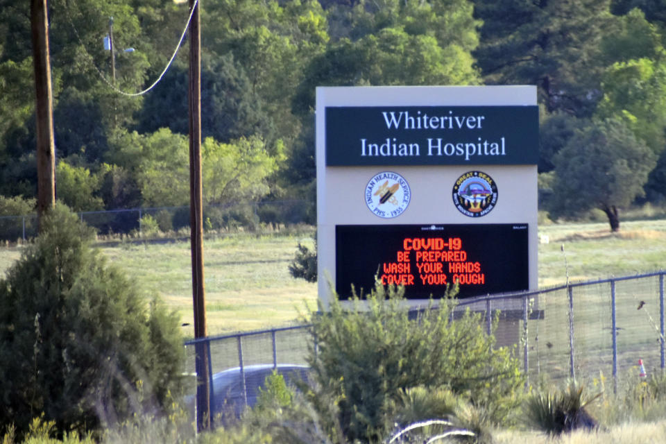 This Thursday, June 25, 2020 photo provided by C.M. Clay, shows sign at the entrance to the Whiteriver Indian Hospital in Whiteriver, Ariz., on the Fort Apache Reservation, The reservation, home to the White Mountain Apache Tribe, will be under lockdown this weekend to help slow the spread of the coronavirus. (C.M. Clay/White Mountain Apache Tribe via AP)