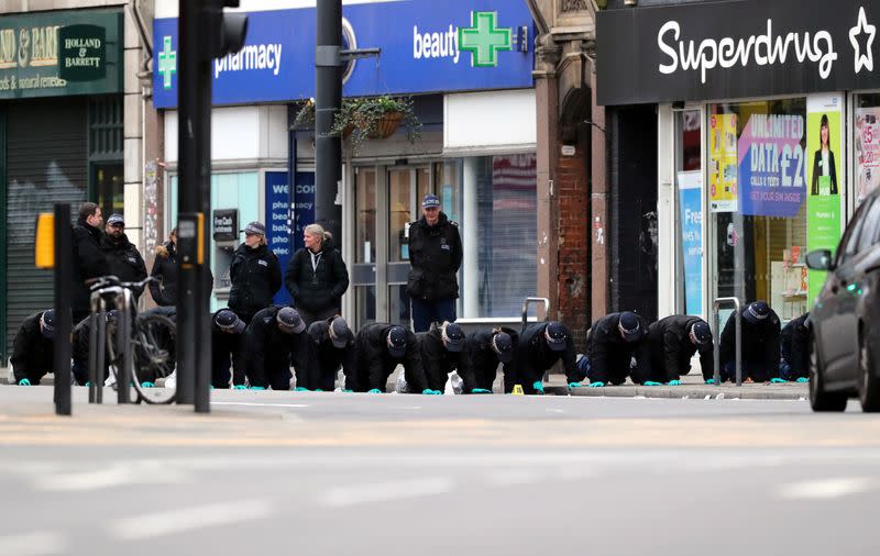 Police officers work near the site where a man was shot by armed officers in Streatham, south London