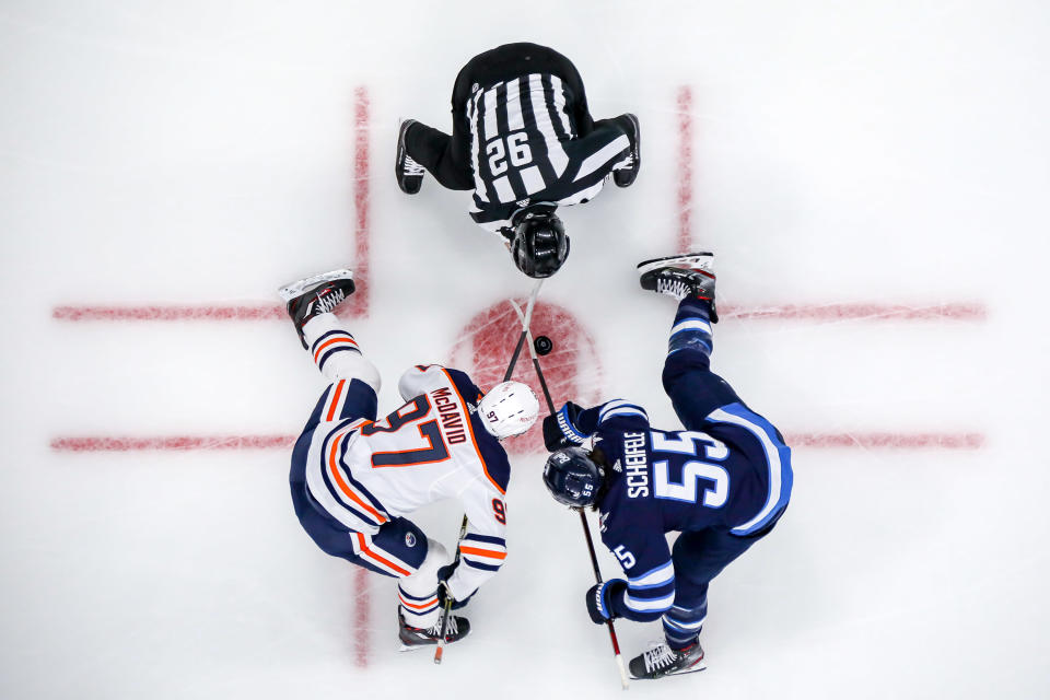 WINNIPEG, MB - APRIL 28: Connor McDavid #97 of the Edmonton Oilers and Mark Scheifele #55 of the Winnipeg Jets take a first period face-off at the Bell MTS Place on April 28, 2021 in Winnipeg, Manitoba, Canada. (Photo by Jonathan Kozub/NHLI via Getty Images)