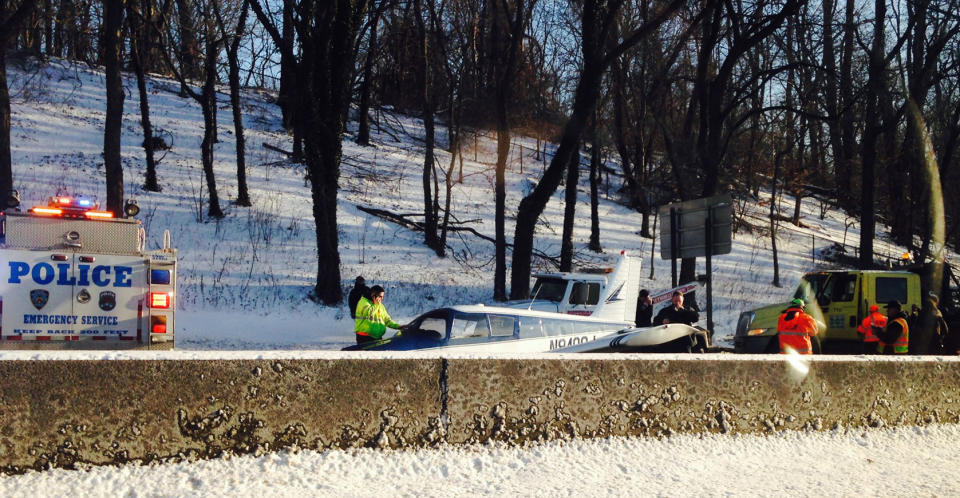 In this photo provided by Patricia Sapol, emergency personnel respond to a light airplane that made an emergency landing on the Major Deegan Expressway in the Bronx borough of New York, Saturday, Jan. 4, 2014. No major injuries were reported but northbound traffic was halted as fuel was removed from the aircraft before it could be removed from the highway. (AP Photo/Patricia Sapol)