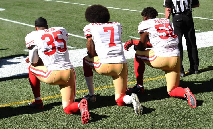 From left, Eric Reid, Colin Kaepernick and Eli Harold of the San Francisco 49ers kneel on the sidelines during the national anthem. (Photo: Steve Dykes/Getty Images)