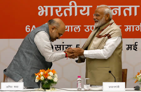 India's Prime Minister Narendra Modi shakes hands with the Bharatiya Janata Party (BJP) President Amit Shah during a thanksgiving ceremony by BJP leaders to its allies at the party headquarters in New Delhi, May 21, 2019. REUTERS/Anushree Fadnavis/Files