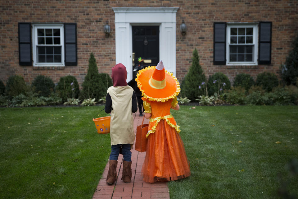 Kids dressed in costumes wait for candy while trick or treating during Halloween in Port Washington, New York, October 31, 2014. REUTERS/Shannon Stapleton (UNITED STATES - Tags: SOCIETY)