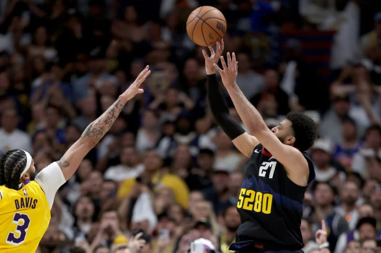 Jamal Murray (D) inscrit le panier décisif pour les Nuggets face aux Lakers d'Anthony Davis (G), en match de play-off de NBA, le 22 avril 2024 (MATTHEW STOCKMAN)