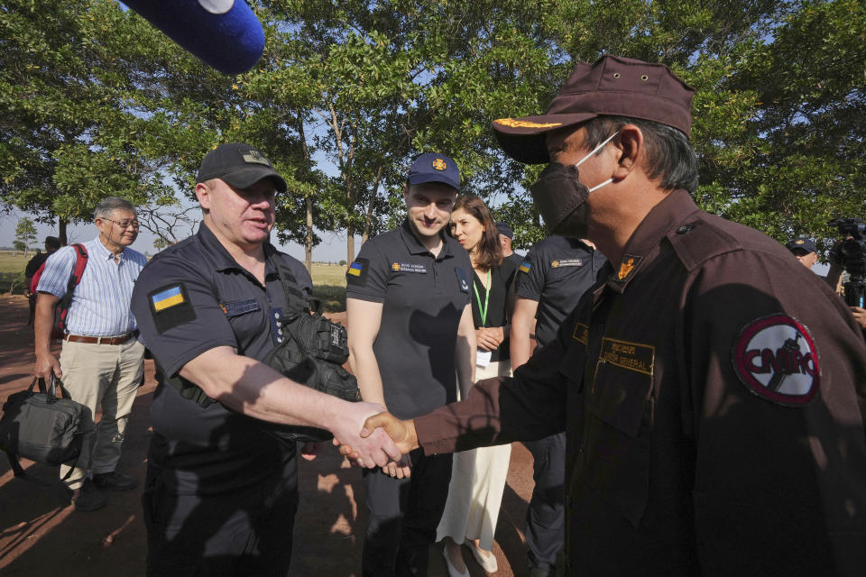 Director General of Cambodia Mine Action Center Heng Ratana, right, shakes hands with Ukrainian deminers during a tour of the Peace Museum Mine Action in Siem Reap province, northwestern Cambodia, Friday, Jan. 20, 2023. Cambodian experts, whose country has the dubious distinction of being one of the world's most contaminated by landmines, walked a group of Ukrainian soldiers through a minefield being actively cleared hoping their decades of experience will help the Europeans in their own efforts to remove Russian mines at home. (AP Photo/Heng Sinith)