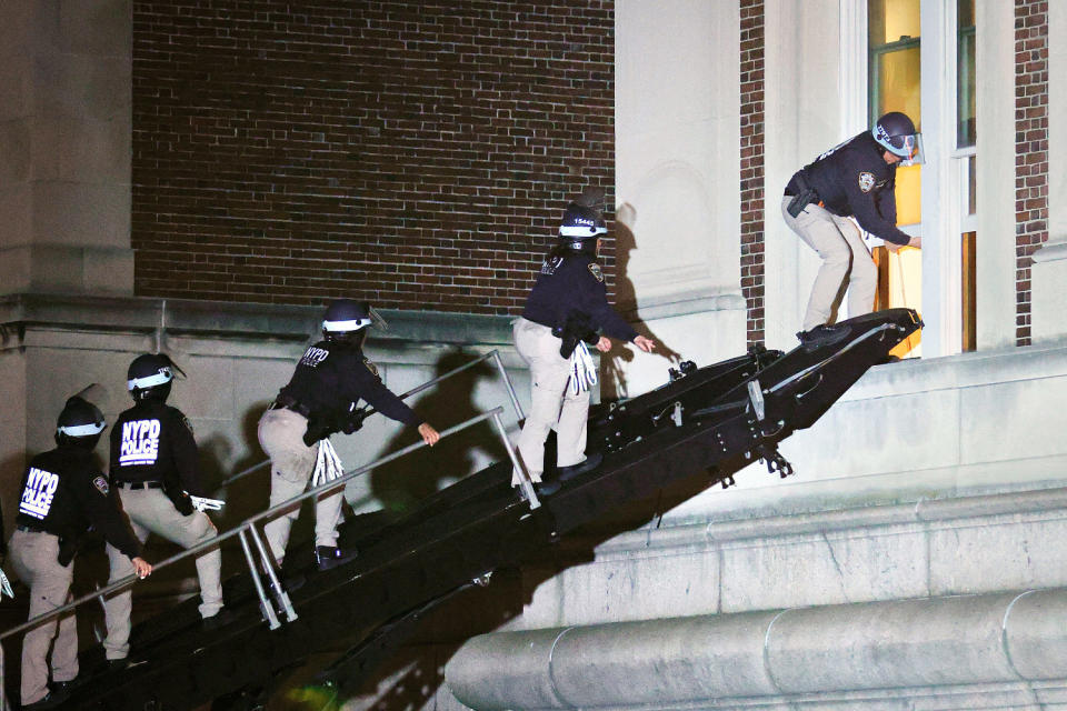 NYPD officers in riot gear break into a building at Columbia University. (Kena Betancur / AFP - Getty Images)