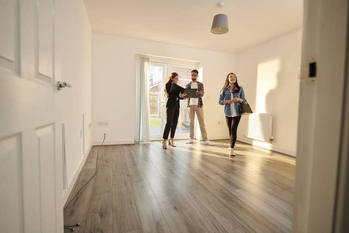 Potential homebuyers walking into a home tour with their real estate agent.