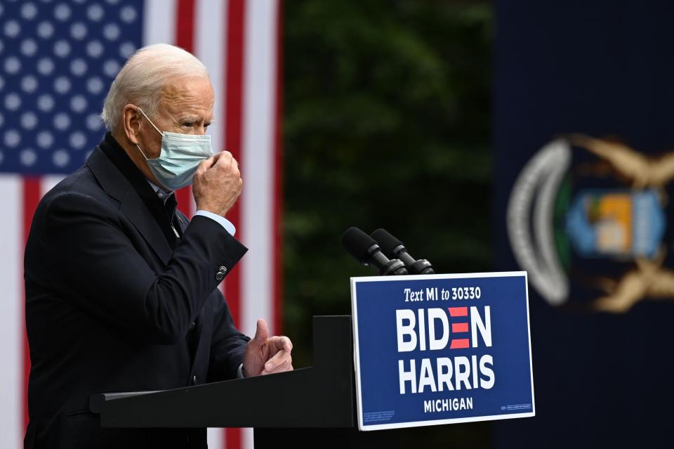 Democratic presidential nominee Joe Biden adjusts his facemask as he speaks during a campaign event in Grand Rapids, Michigan on October 2, 2020.