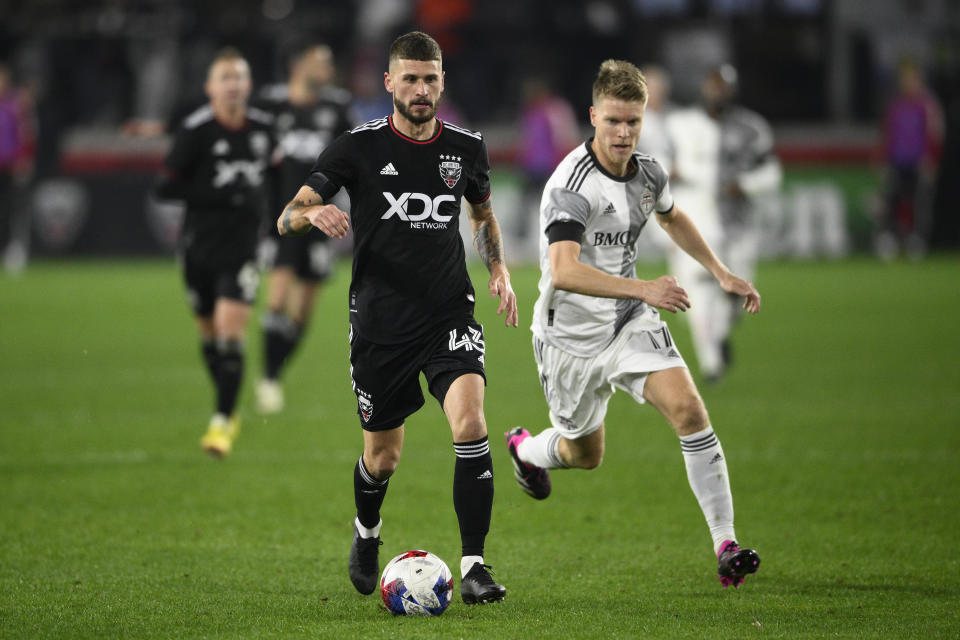 D.C. United midfielder Mateusz Klich (43) dribbles the ball next to Toronto FC defender Sigurd Rosted (17) during the second half of an MLS soccer match, Saturday, Feb. 25, 2023, in Washington. (AP Photo/Nick Wass)