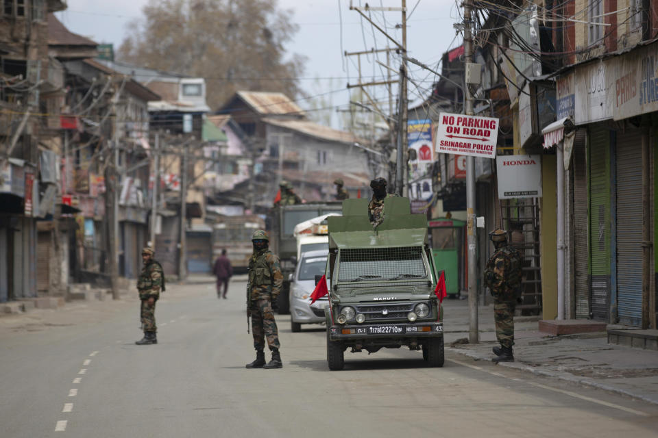 FILE - In this Tuesday, March 31, 2020, file photo, Indian army soldiers stand guard while they wait for a fellow soldier shopping during lockdown in Srinagar, Indian controlled Kashmir. In a rare admission of wrongdoing, the Indian military on Friday, Sept. 18, said its soldiers in Kashmir exceeded their legal powers in the killings of three local men it had described as Pakistani terrorists. On July 18, the Indian army said its soldiers killed three “unidentified Pakistani terrorists” in the southern Shopian area. About a month later, three Kashmiri families in Rajouri identified the victims as their missing relatives using photographs of the bodies that circulated on social media, and filed a complaint with police. (AP Photo/ Dar Yasin)