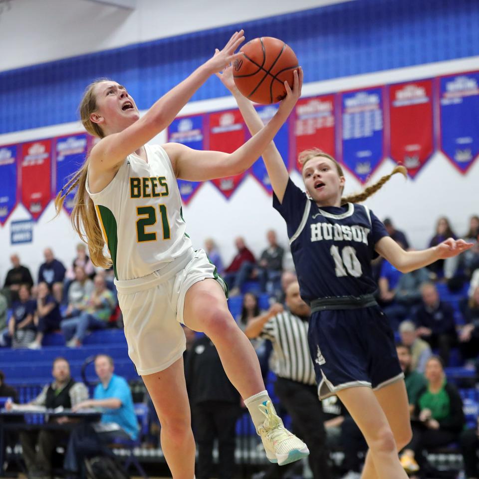 Medina's Izzy Kurka, left, shoots a layup ahead of Hudson guard Addie Lawton during the second half of a Division I district semifinal, Tuesday, Feb. 27, 2024, in Ravenna.