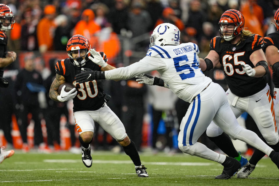 Cincinnati Bengals running back Chase Brown (30) tries to cut away from Indianapolis Colts defensive end Dayo Odeyingbo (54) in the second half of an NFL football game in Cincinnati, Sunday, Dec. 10, 2023. (AP Photo/Carolyn Kaster)