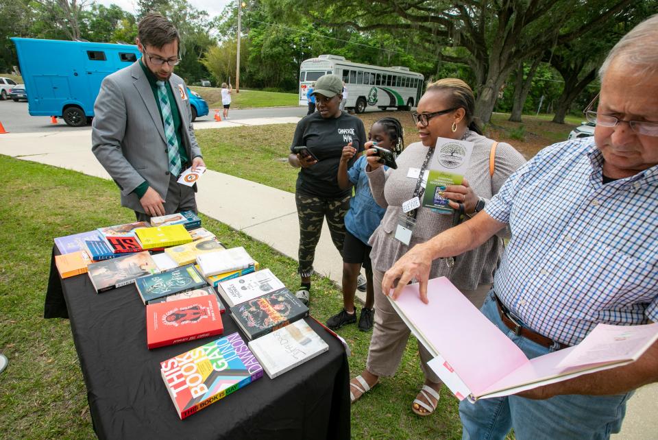 Chris Mruzek shows a table of books he feels should be banned from schools. The table was set up outside the Marion Technical Institute in Ocala, where the Marion County School Board was meeting on Tuesday.